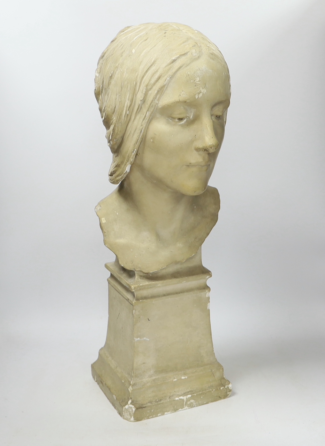 A plaster bust of a woman’s head on a square pedestal, 58cm